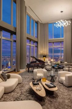 a living room filled with lots of furniture next to large windows and a piano in the corner