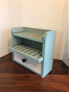 a blue and white shelf sitting on top of a wooden floor