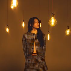 a woman standing in front of some light bulbs