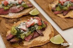 two wooden boards topped with tacos covered in toppings