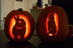 two carved pumpkins sitting on top of a table