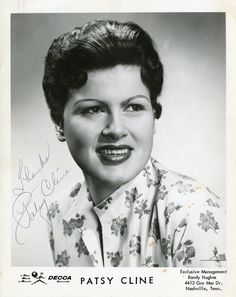 an old black and white photo of a woman with short hair smiling for the camera