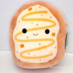 a stuffed toy with an orange frosted donut on it's face and eyes