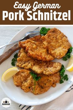 easy german pork schnitzel on a white plate with lemon wedges