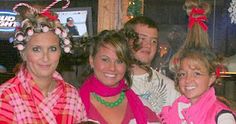 a group of people standing next to each other in front of a christmas tree with candy canes on their heads