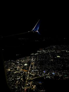 an airplane wing flying over a city at night