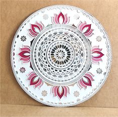 a white plate with red and black designs on the bottom is sitting on a cardboard box