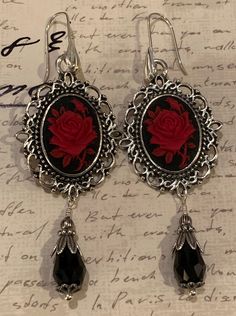 "Beautiful and understated, these dangle earrings feature a red, black, purple or ivory rose on a black or green background resin cameo set in a Victorian antique silver or antique bronze setting. A black (or green) faceted Czech drop with antique silver or bronze filigree findings completes the look. Convo me if you have a custom request in mind as I can create whatever you'd like. Beautiful sterling silver shell ear wires are pictured but sterling silver lever-backs, sterling silver ball posts Silver Gothic Earrings For Valentine's Day, Cameo Drop Earrings As Gift, Rose Metal Jewelry For Party, Cameo Drop Earrings Jewelry Gift, Gift Cameo Drop Earrings Jewelry, Gothic Metal Earrings For Valentine's Day, Black Nickel-free Jewelry For Valentine's Day, Nickel-free Black Jewelry For Valentine's Day, Gothic Dangle Earrings For Valentine's Day