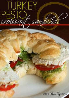 a turkey pesto croissant sandwich cut in half on a white plate with text overlay