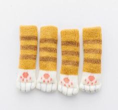 four pairs of yellow and white knitted socks with pink dots on the bottom, one pair