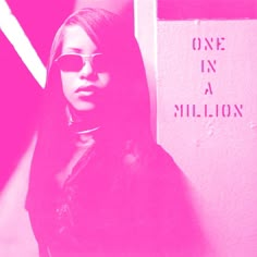 a woman wearing sunglasses standing in front of a pink wall with the words one in a million written on it