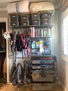 an organized closet with shoes, bags and other items on the shelves in front of it