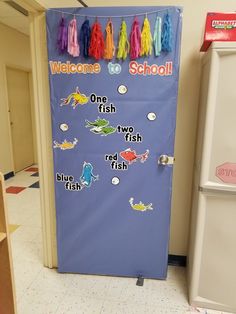 a blue door decorated with fish and rainbow tassels