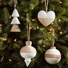 wooden ornaments hanging from a christmas tree in the shape of heart and arrow, with lights on