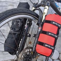 a bicycle with a red bag attached to it's front wheel