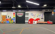 an indoor basketball court decorated with musical instruments and music notes on the wall, painted in bright colors