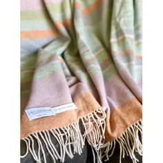 an image of a blanket with fringes on the bottom and one in green, orange and pink