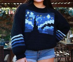 a woman is smiling while wearing a sweater with the image of the starr wars on it