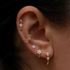 a woman's ear with three different types of piercings