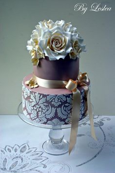 a three tiered cake decorated with flowers and ribbons