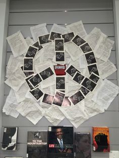 a display case with various records on the wall and in front of it is a peace sign made out of newspapers