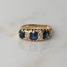 An antique 18 carat gold ring with sapphires and diamonds.  CONDITION: Wear consistent with age and use. Please see photos for more detail. All stones present. HALLMARKED 18 CARAT GOLD, ASSAYED BIRMINGHAM 1911 BAND WIDTH NARROWEST: 1.5mm RING SIZE: UK: K 1/2 | US: 5 1/2 SETTING SIZE: 18mm x 6mm SETTING HEIGHT: 4mm SAPHIRE SIZE:  4mm x 3mm 5mm x 4mm DIAMOND SIZE: 1.5mm (0.04 carat) WEIGHT: 4.7g (DDZ) Gold Sapphire Ring Engagement, Vintage Birthstone Ring, Mothers Rings, Gold Sapphire Ring, Sapphire And Diamond Ring, Mother Rings, Multi Stone Ring, Jewelry Inspo, Multi Stone