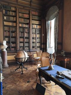 an old library with many bookshelves and chairs in the room, all lined up