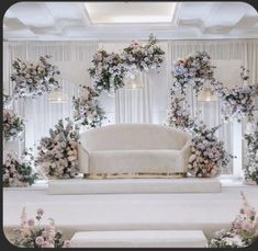 a white couch sitting on top of a stage covered in flowers