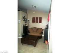 a living room with a brown couch and pictures on the wall above it's door