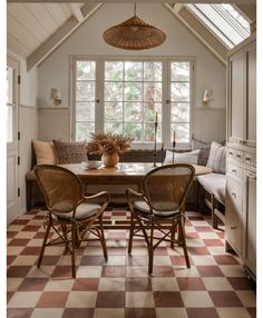 a dining room table and chairs in front of a large window with a checkered floor