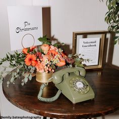 an old fashioned phone sitting on top of a table next to a bouquet of flowers