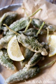 fried green beans with lemon wedges and pesto