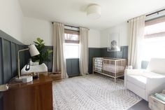 a baby's room with a crib, rocking chair and large window in the corner