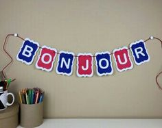 a bunting banner with the words bonjou on it in red, white and blue