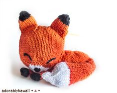 an orange knitted fox laying on its side