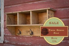 the sale sign is displayed on an old red building with hooks and wooden shelves in it