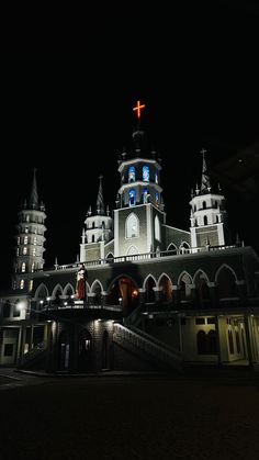 a church lit up at night with a cross on top