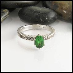 This Josephine's Knot band set with a 5x7mm Tsavorite Garnet. The strands intertwine continuously around the band to symbolize eternal love. This oval tsavorite lover's knot ring pictured in 14K White gold, but is also available in 14K Yellow, Rose or White Gold in sizes 4 - 12. Please message us for extended sizing prices. If you love this ring, but tsavorite just isn't for you send us a message! We'd be happy to find and price the perfect gemstone for you. Whether you want an emerald cut moiss Oval Tsavorite Ring In White Gold, Oval Tsavorite White Gold Ring, Oval Green Tsavorite Jewelry, Oval Tsavorite Jewelry For Anniversary, Oval Peridot Solitaire Jewelry, Tsavorite Solitaire Ring, Tsavorite Engagement Ring, Knot Engagement Ring, Celtic Love Knot