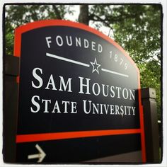 a sign for sam houston state university in front of trees