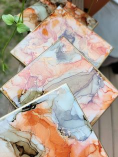 three pieces of colorful marble sitting next to each other on top of a wooden table