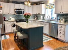 a kitchen with white cabinets and an island in front of the stove, sink, microwave and dishwasher