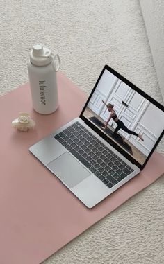 an open laptop computer sitting on top of a pink mat