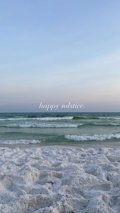 there is a surfboard that is on the sand at the beach and it says happy solstice