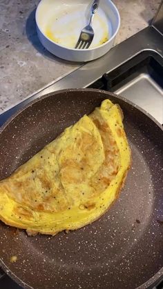 an omelet is being cooked in a frying pan