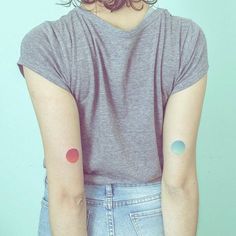 the back of a woman's shoulder with three dots on it