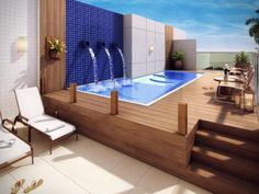 an indoor swimming pool surrounded by wooden steps and blue tiled walls with water running down the side