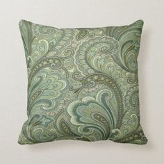 a green and blue pillow with an intricate design