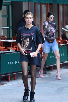 a woman walking down the street in short shorts