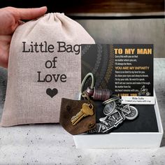 a bag that has some keys in it and is next to a card with the message little bag of love