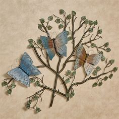 three butterflies on a tree branch with leaves and branches attached to the back of it